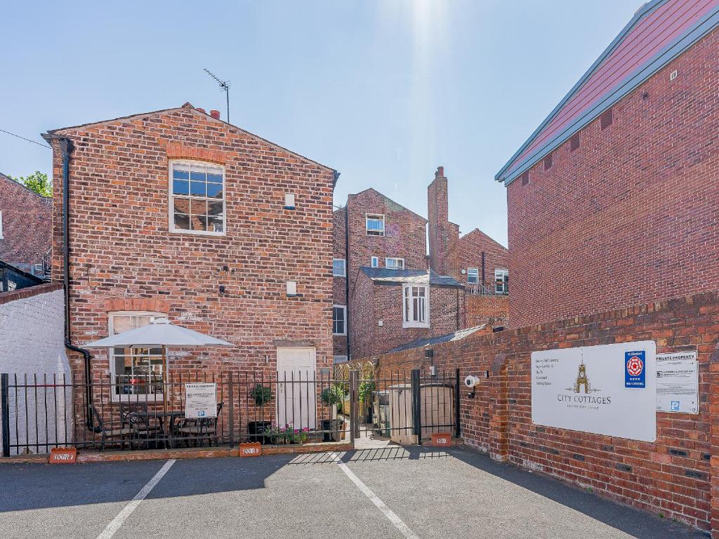 un edificio de ladrillo con una mesa y una sombrilla en Flat 4A, en Chester