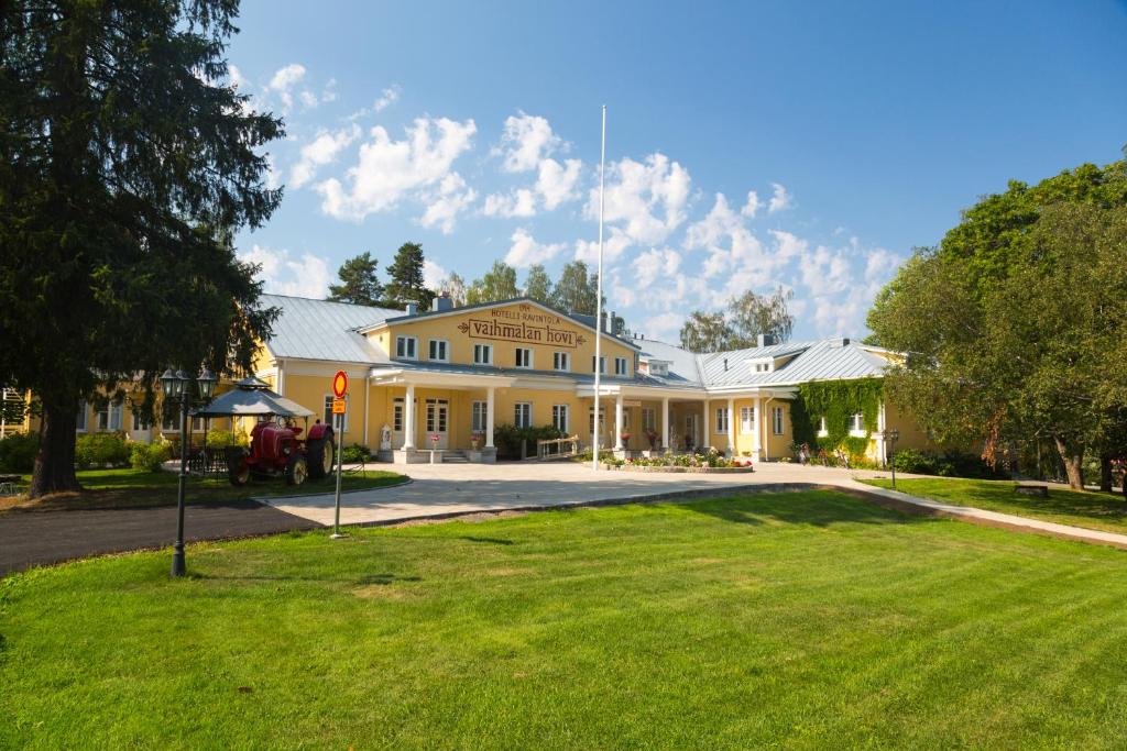 a large house with a green lawn in front of it at Vaihmalan Hovi in Lempäälä