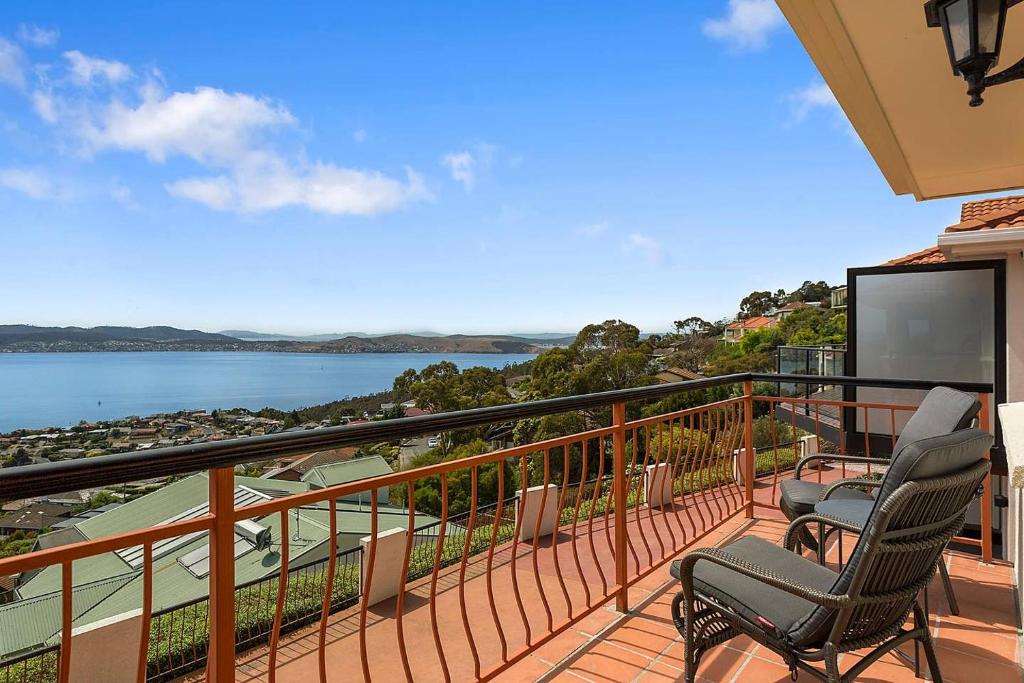 a balcony with two chairs and a view of the water at Scenic Sandy Bay Home with Stylish Interior in Sandy Bay