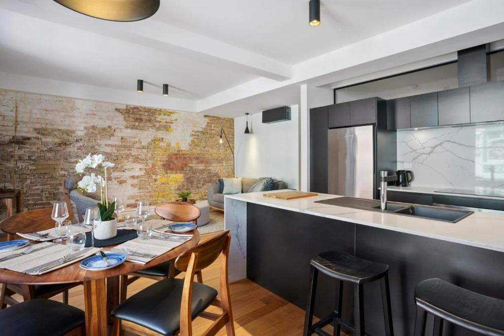 a kitchen and living room with a wooden table and chairs at Saddlers House - Vintage Suite - Cafe Lifestyle in Hobart