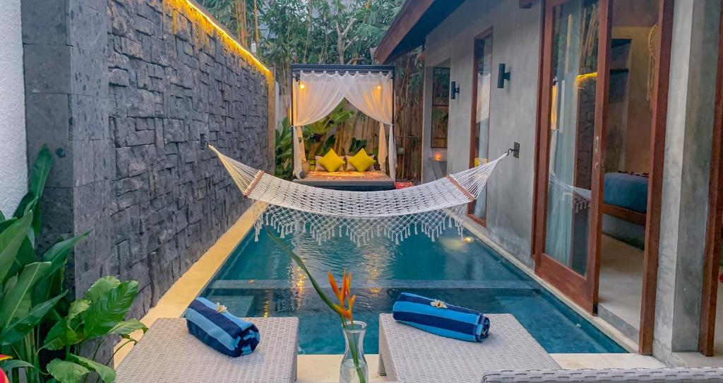 Vinna Villa Seminyak في كيروبوكان: حمام سباحة مع أرجوحة بجوار منزل