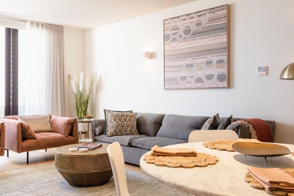 ein Wohnzimmer mit einem Sofa und einem Tisch in der Unterkunft The Rox - Luxe Hobart City Apartment in Hobart