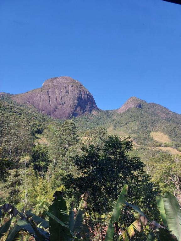 a mountain in the middle of a forest with trees at Lumiar Eco Lodge - Chalé Pedra Riscada in Nova Friburgo