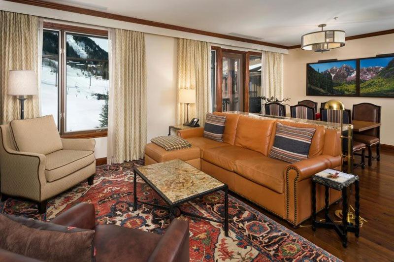 Aspen Ritz-carlton 2 Bedroom Ski In, Ski Out Residence With Access To Slopeside Heated Pools And Hot Tubs في أسبين: غرفة معيشة كبيرة مع أريكة وكراسي