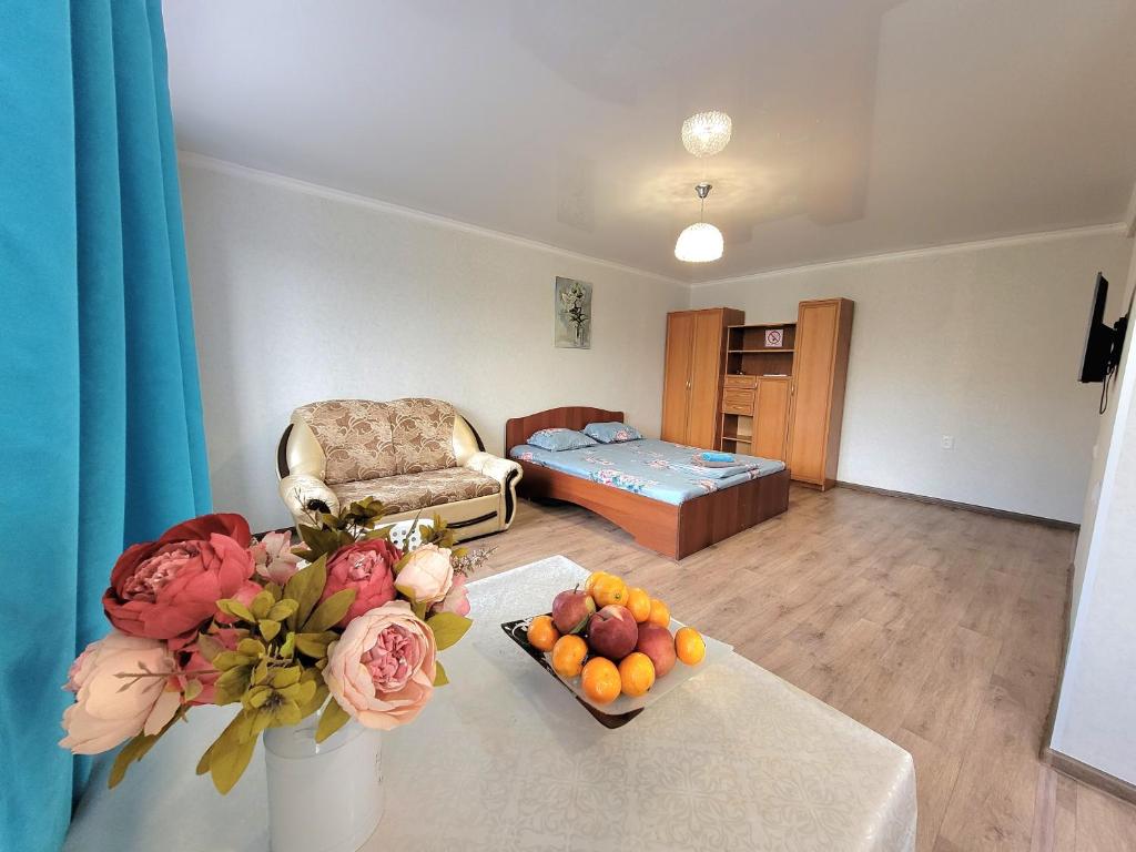 een woonkamer met een tafel met een fruitschaal bij 1 комн. Апартаменты на Абая 122 in Köksetaw