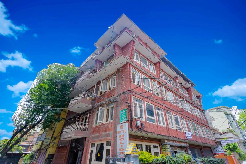 un edificio rosso all'angolo di una strada di OYO 795 Hotel Holiday Inn a Kathmandu