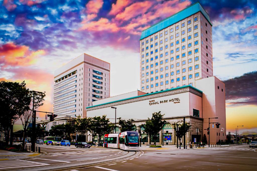 un autobús está estacionado frente a un edificio en Oarks Canal Park Hotel Toyama en Toyama