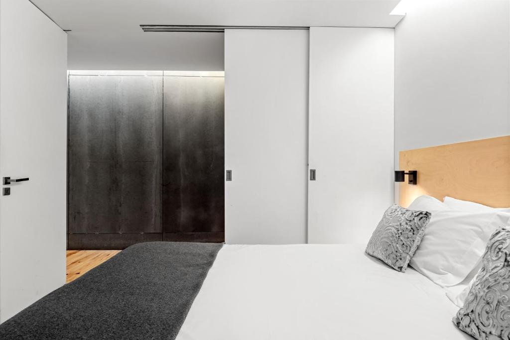 um quarto com uma cama branca e um closet em OX Apartments B Places no Porto
