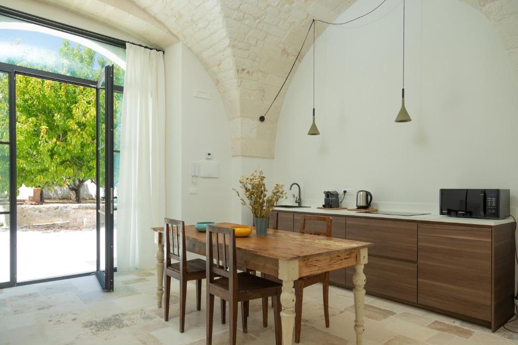 - une cuisine avec une table en bois et des chaises dans l'établissement Palazzo Bergamotti, à Ostuni