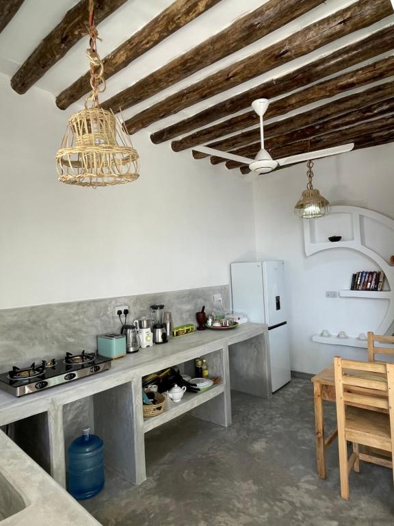 a kitchen with a table and a refrigerator at Olamanga Beach Villa in Jambiani