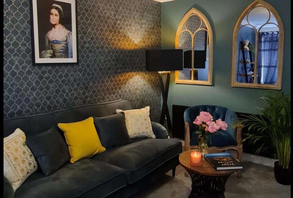sala de estar con sofá negro y mesa en Stylish Scottish House with garden & parking en Perth
