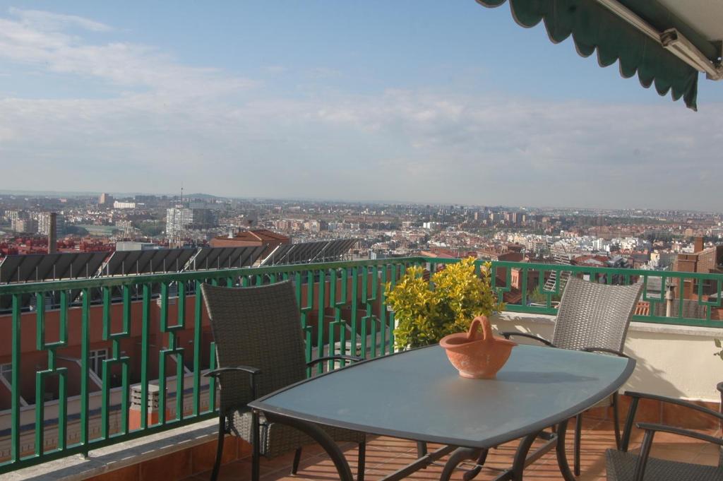 uma mesa e cadeiras numa varanda com vista em Atico Latina em Madrid