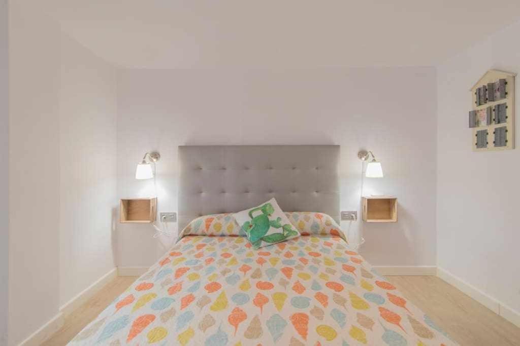 um quarto com uma cama e duas luzes na parede em Precios apartamento Centro ciudad em Granada