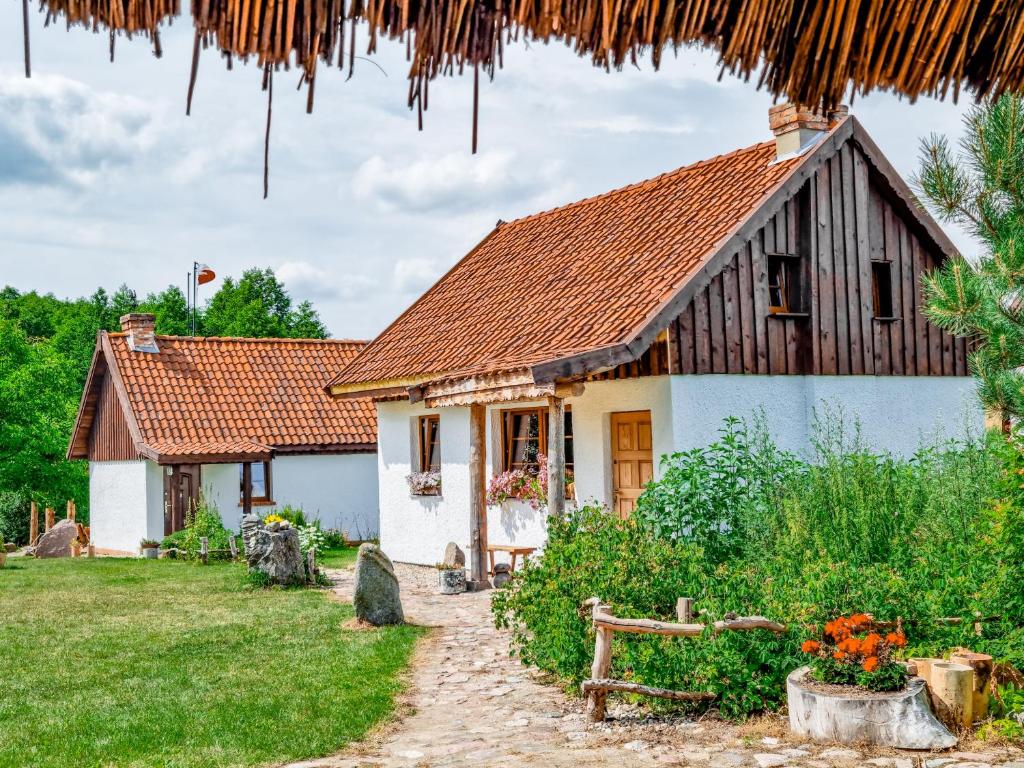 a small white house with a brown roof at Siemionówka in Popowo Salęckie