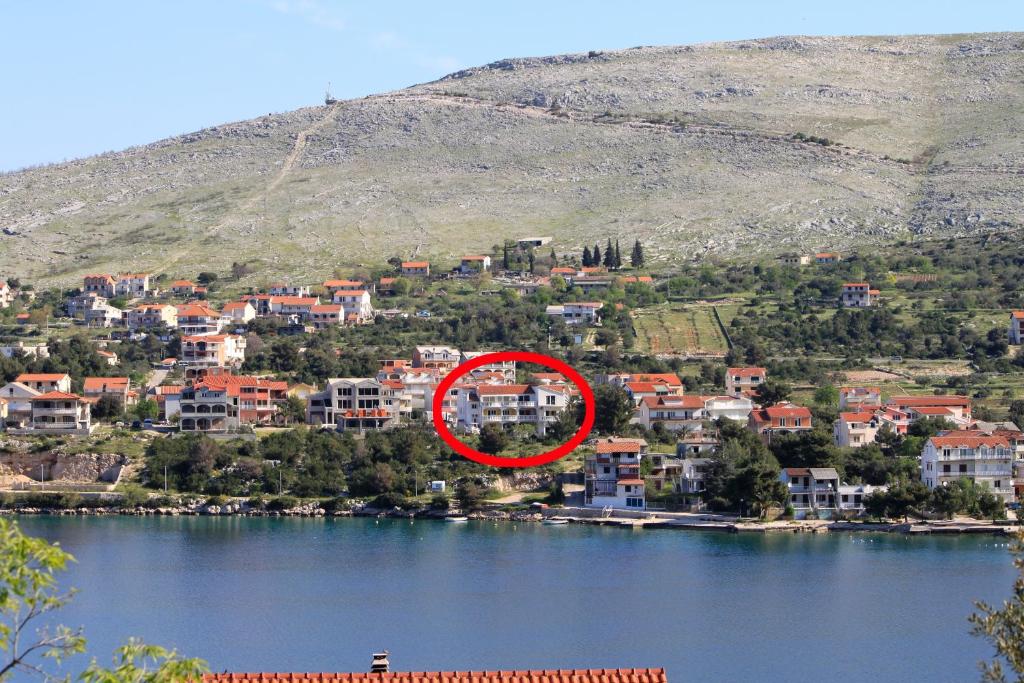 un cercle rouge au milieu d'une ville sur un lac dans l'établissement Apartments by the sea Grebastica, Sibenik - 4254, à Šibenik