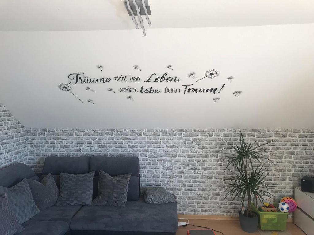 a living room with a couch and a brick wall at FeWoWe Ferienwohnung Wenden in Wenden