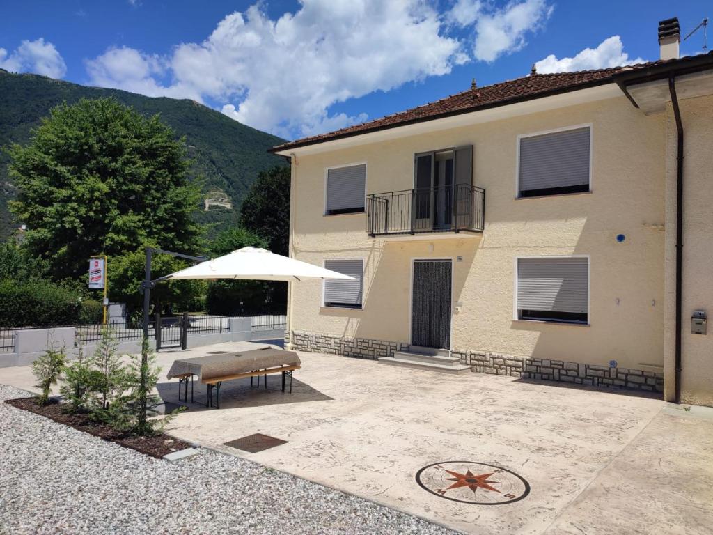 a building with a table and an umbrella in front of it at MARGHERITA'S Guest House in Tarzo