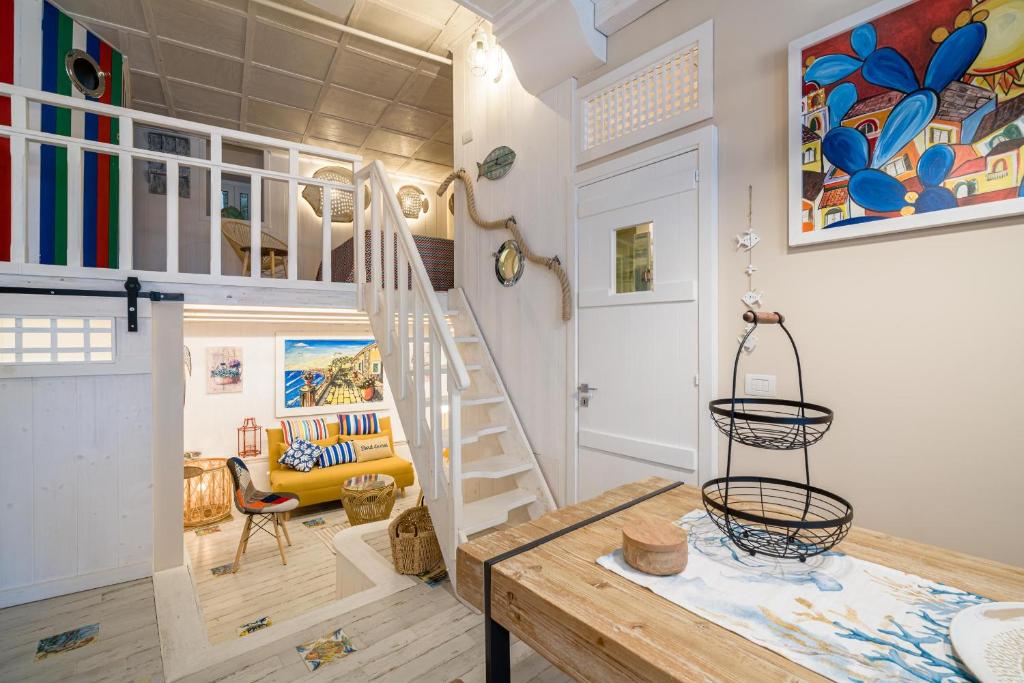 una camera con scala e soggiorno di La Casa di Nonna Piera a Giardini Naxos