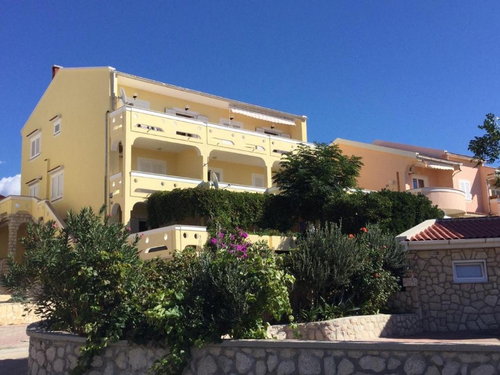 duży budynek z roślinami przed nim w obiekcie Apartments by the sea Kustici, Pag - 4104 w mieście Zubovići