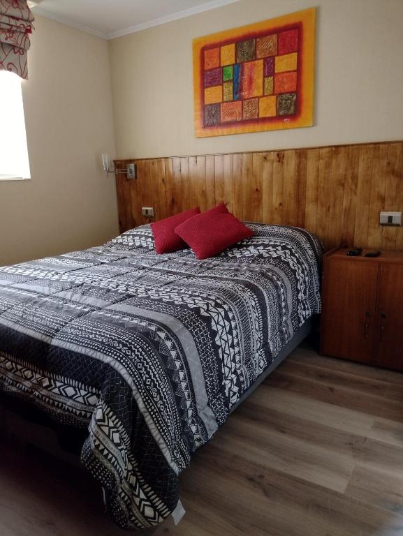 um quarto com uma cama com um cobertor preto e branco em Puerto Perales Talcahuano em Talcahuano