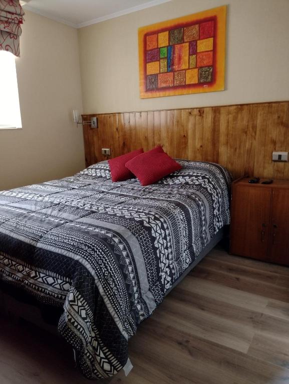 a bedroom with a bed with a black and white blanket at Puerto Perales Talcahuano in Talcahuano