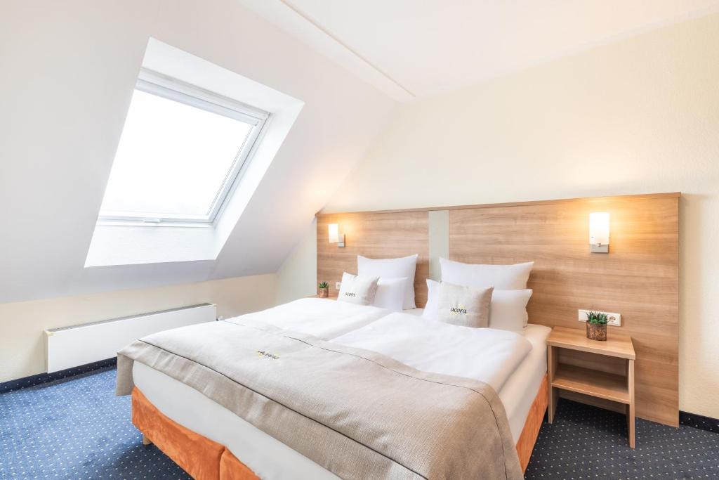 a bedroom with a large bed with a large window at acora Bochum Living the City in Bochum