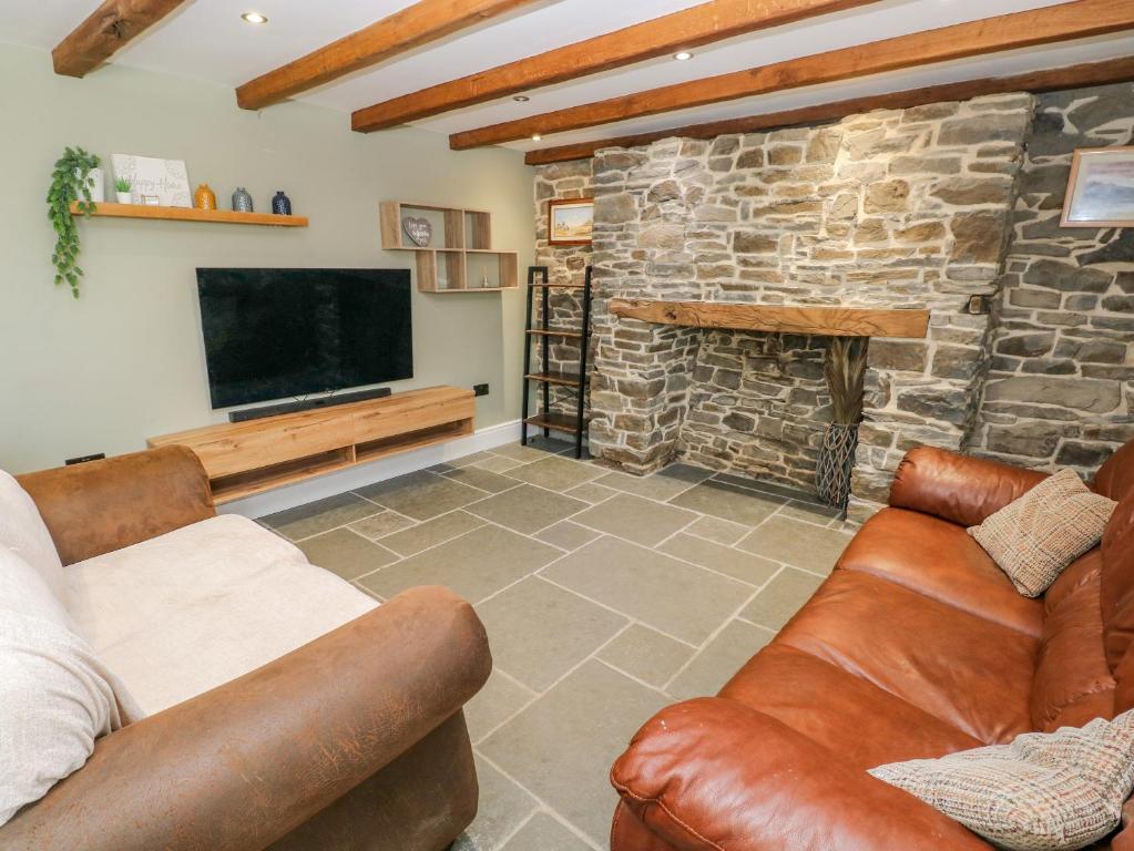 a living room with two couches and a television at Y Bwythyn Bach in Burry Port