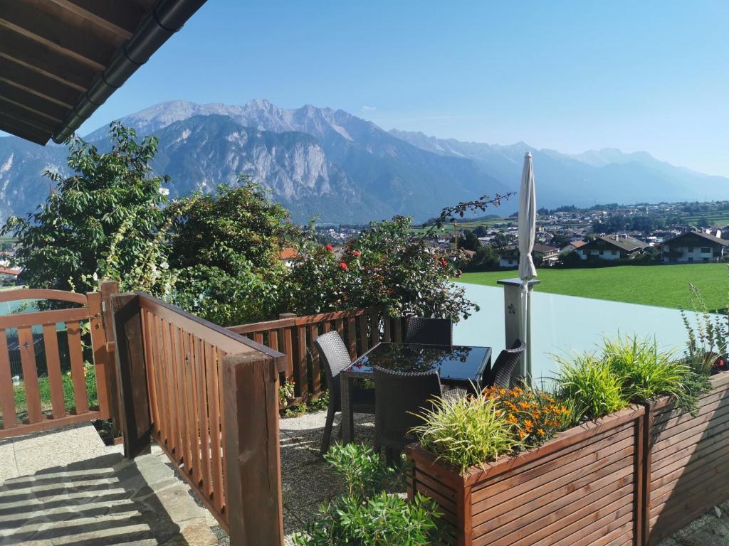 eine Terrasse mit einem Tisch, Stühlen und einem Pool in der Unterkunft Ferienwohnung Salzmann in Innsbruck