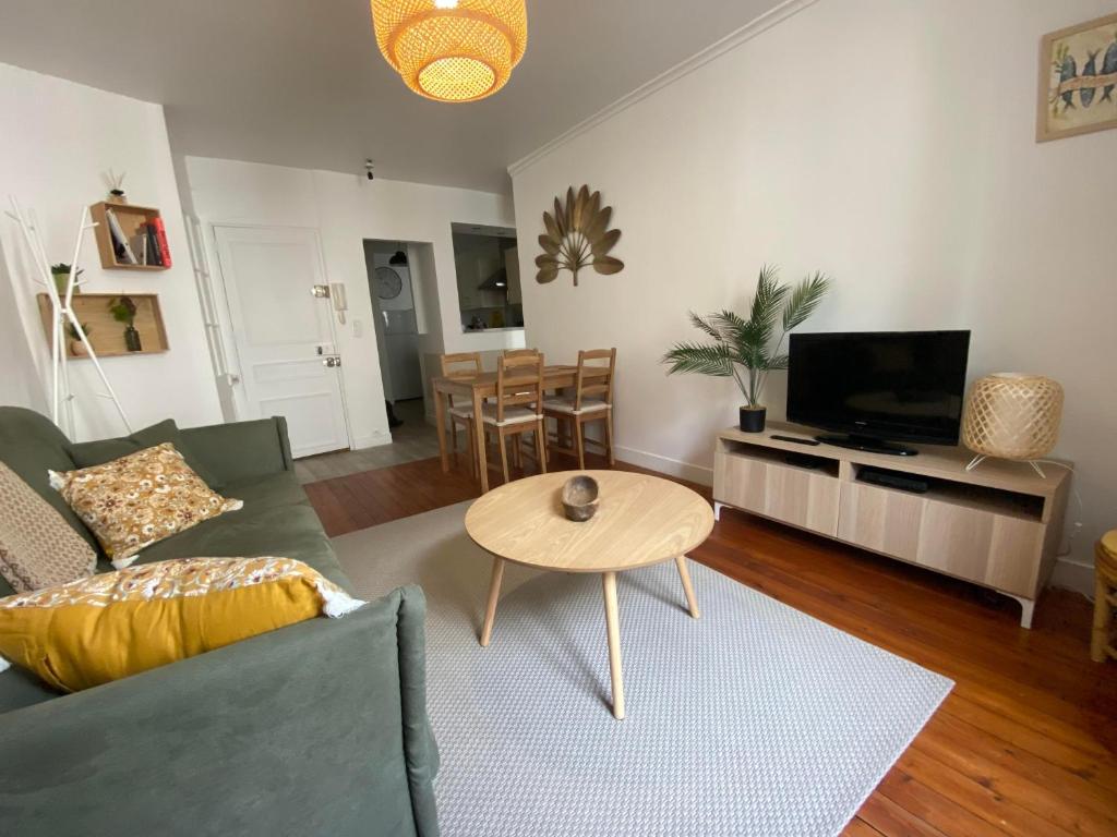 a living room with a couch and a table at L'Abri-gîte - Appartement moderne idéalement situé en centre ville in Dieppe