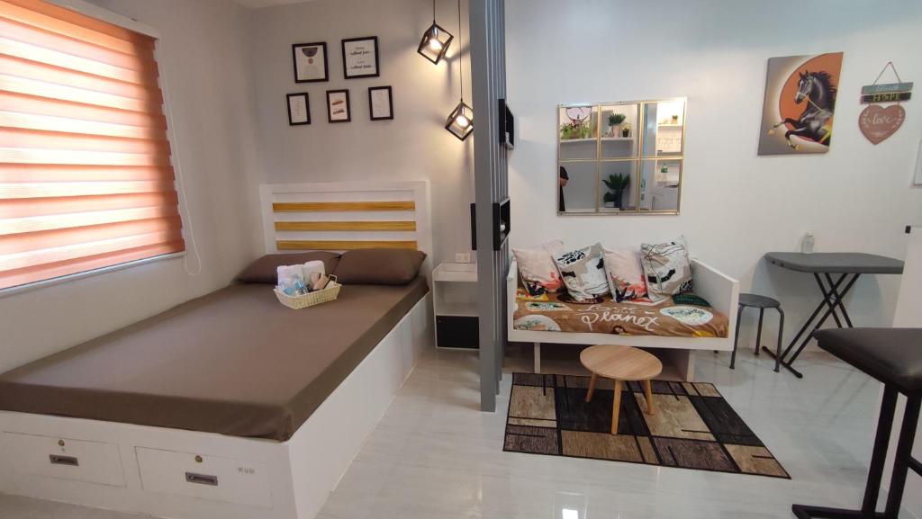 um pequeno quarto com uma cama e uma mesa em CG's place (modern condo in cdo) em Cagayan de Oro