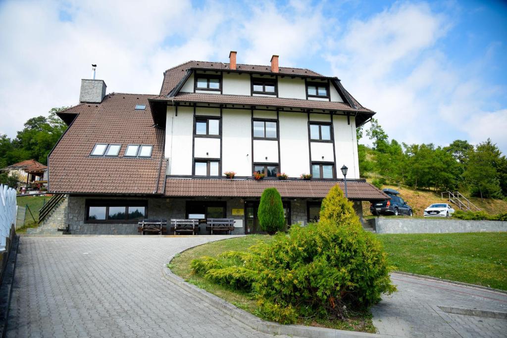 une grande maison blanche avec un toit marron dans l'établissement Villa Mramor, à Brzeće