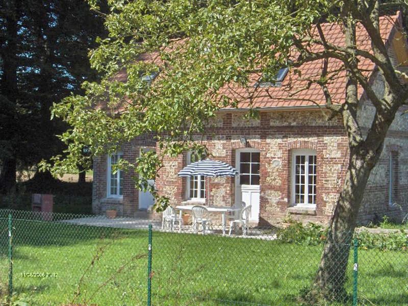 Gîte de la Ferme Dufresne في Bernières: منزل من الطوب مع طاولة وكراسي أمامه