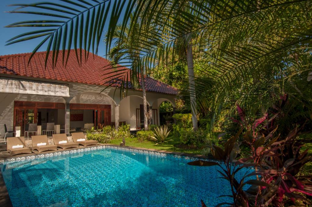 a swimming pool in front of a house at Villa Kelapa in Lovina