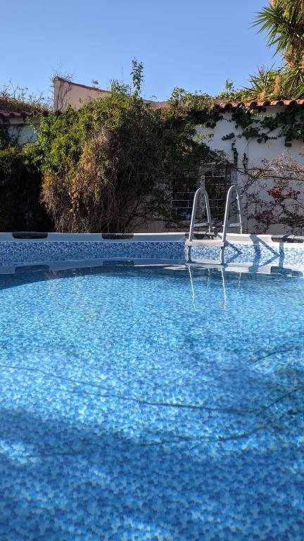 a blue swimming pool with a swing in the water at Estombar Novo in Estômbar