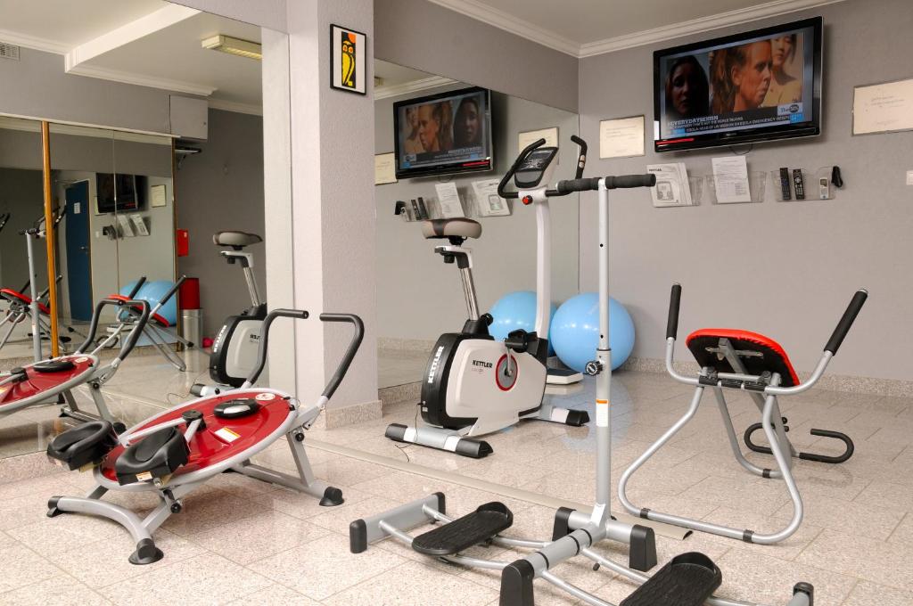 a gym with several exercise equipment in a room at Domus Hotel in Luxembourg