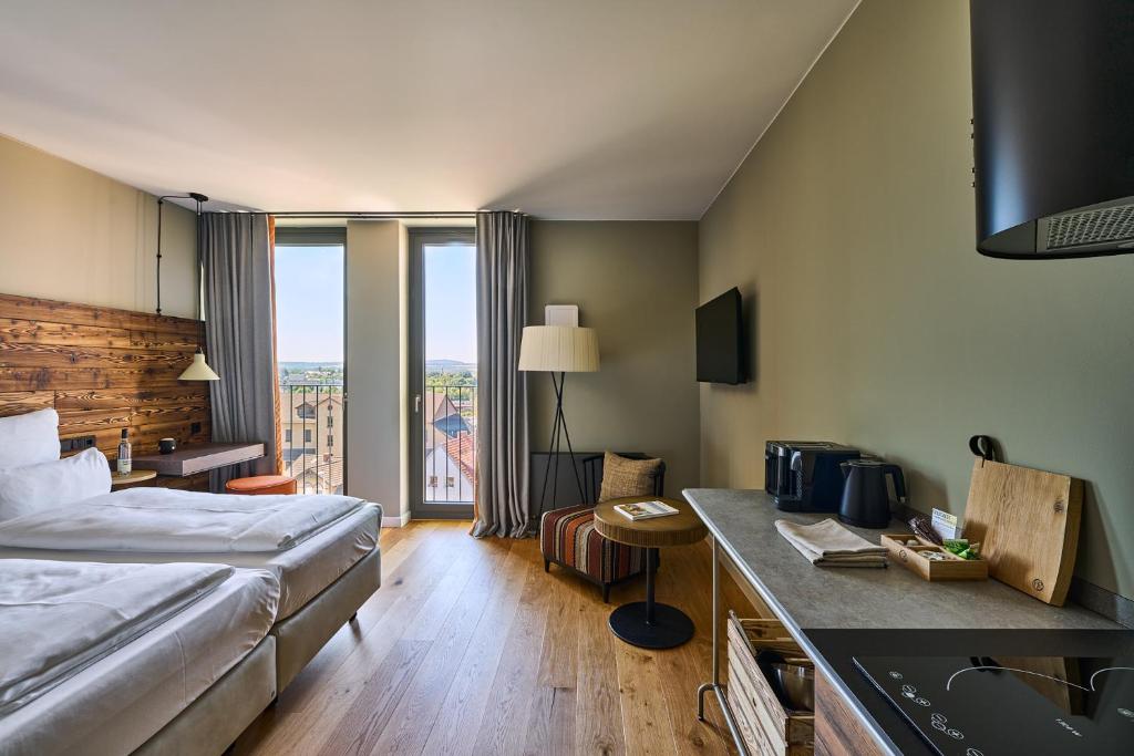 a hotel room with a bed and a desk with a sink at FREIgeist Homes - Serviced Apartments in Göttingen