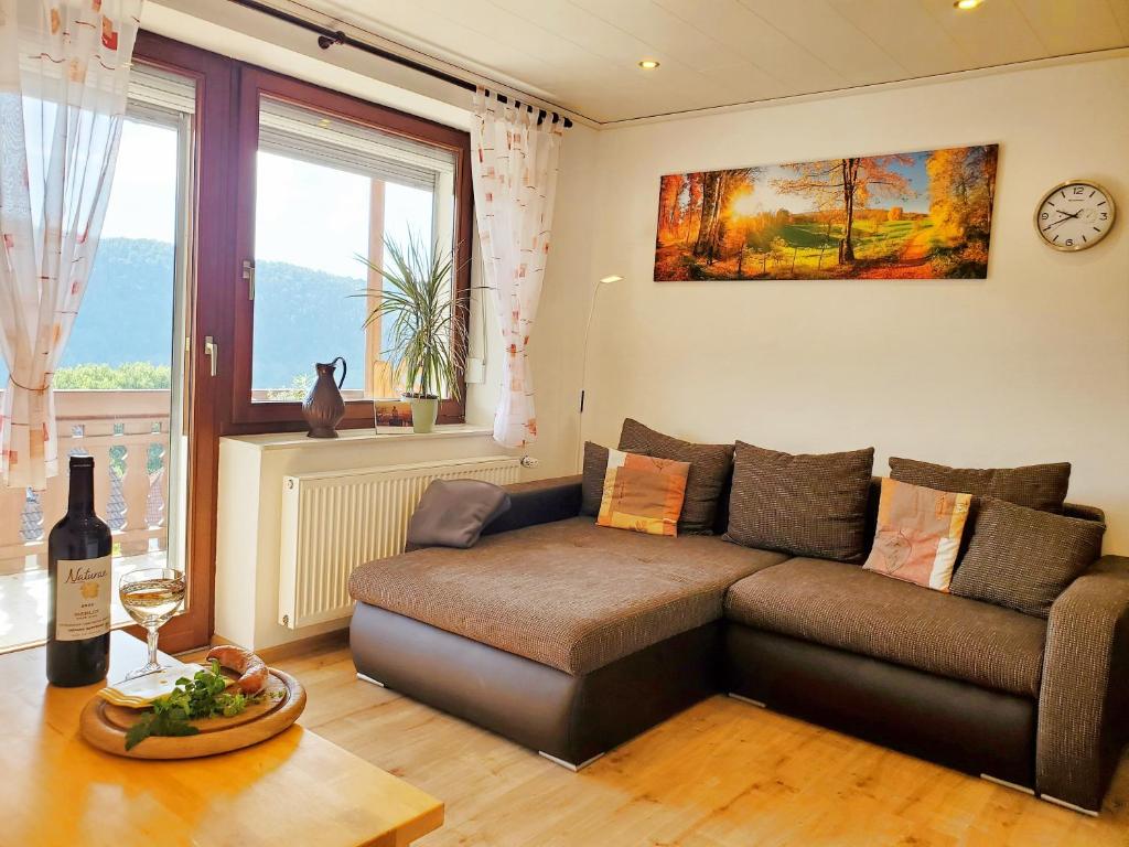sala de estar con sofá y ventana en Ferienwohnung Sonnenblick, en Lago Éder