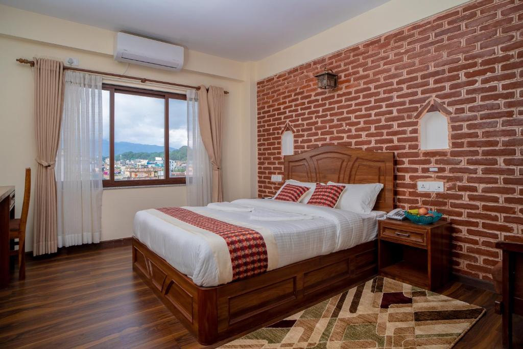 una camera da letto con un muro di mattoni e un letto di Madhuban Hotel a Kathmandu