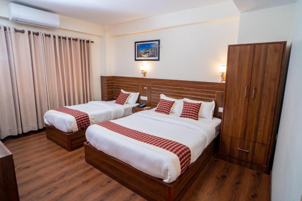 Postel nebo postele na pokoji v ubytování Madhuban Hotel