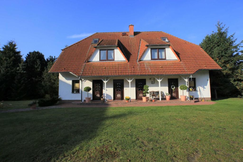 a large white house with a red roof at Ruegen_Fewo 155 in Veikvitz