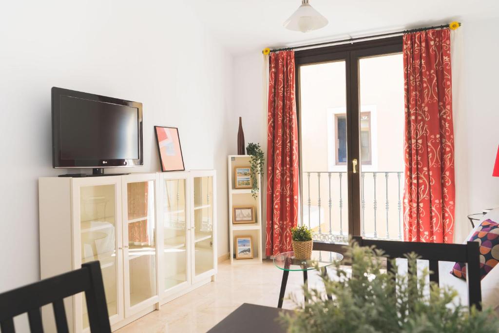 ein Wohnzimmer mit einem Flachbild-TV auf einem Schrank in der Unterkunft Céntrico Apartamento en Calle Carreteria - Malaga in Málaga