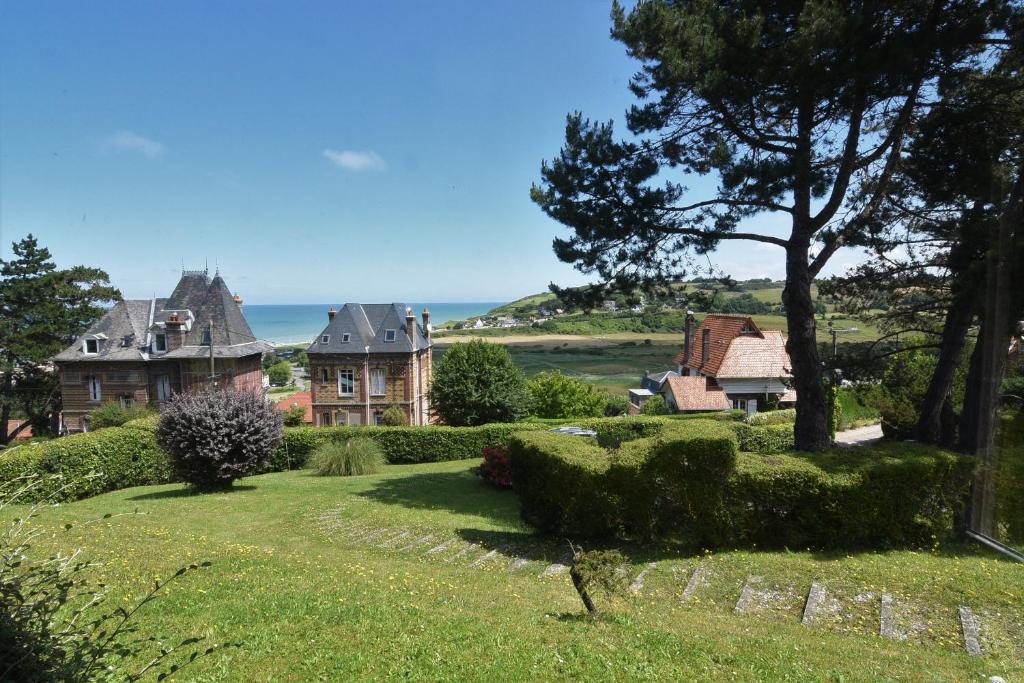 una casa su una collina con l'oceano sullo sfondo di Les Pins Maison Vue sur Mer a Hautot-sur-Mer