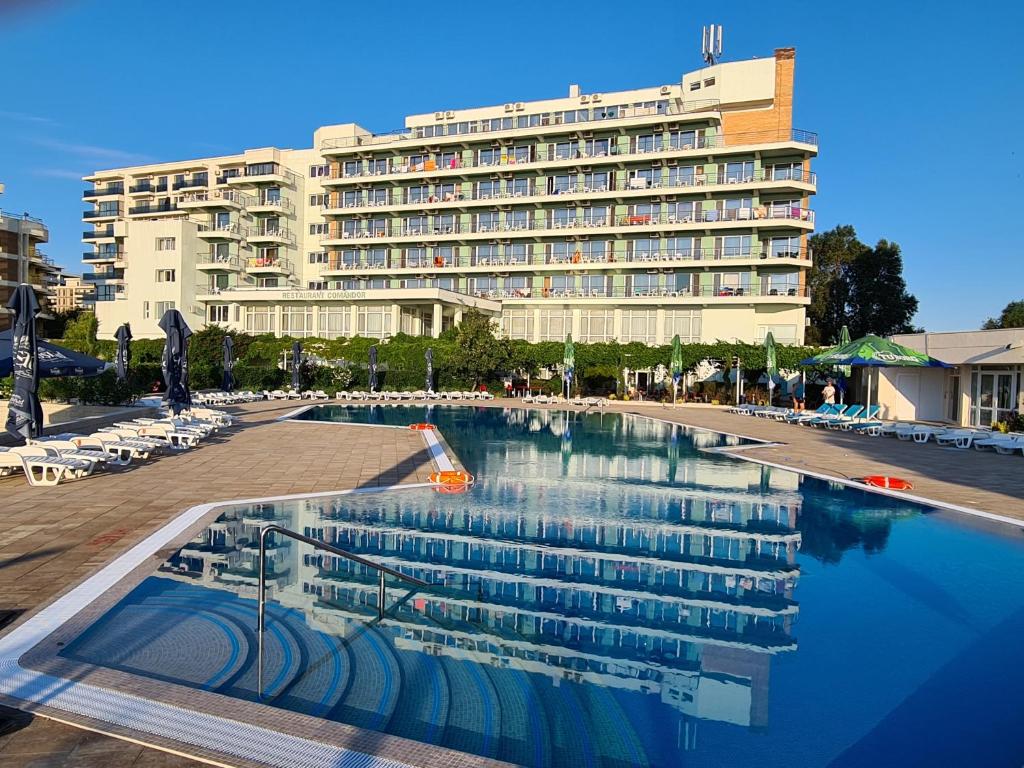 a hotel with a swimming pool in front of a building at Hotel Comandor in Mamaia