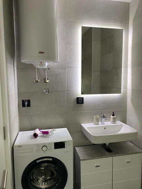 ein Badezimmer mit einer Waschmaschine und einem Waschbecken in der Unterkunft Oasis in Jajinci