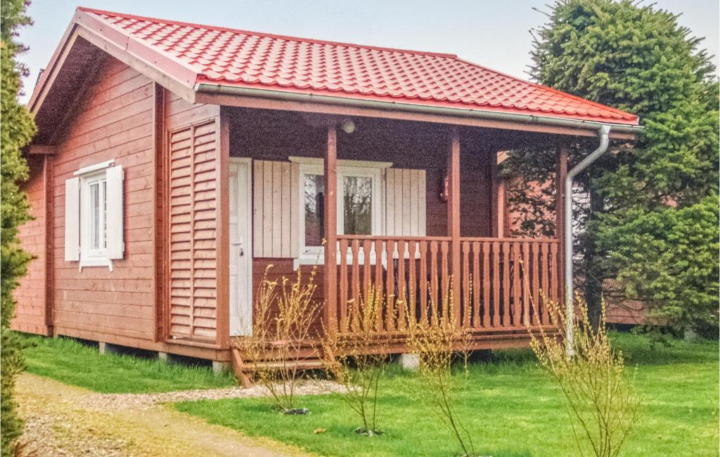 a small wooden house with a porch at Gorgeous Home In Ustronie Morskie With Kitchenette in Ustronie Morskie