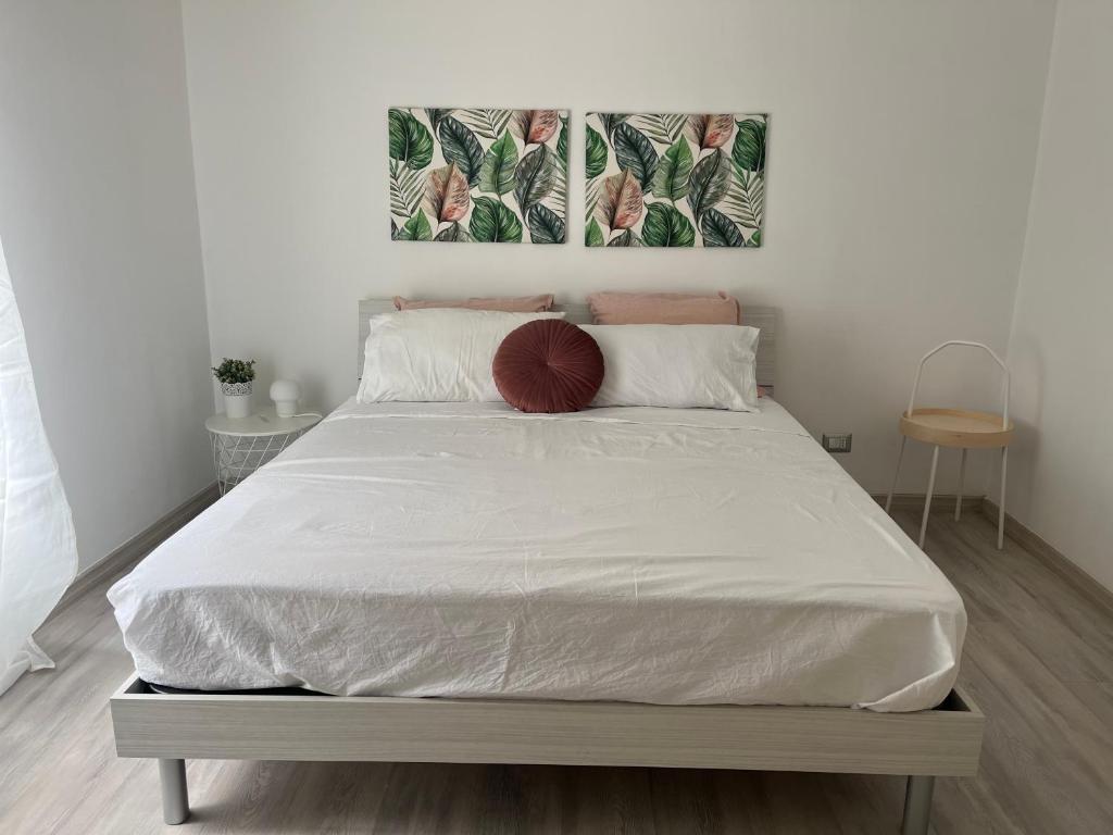 - une chambre avec un grand lit et des draps blancs dans l'établissement You and Me Cagliari, à Cagliari