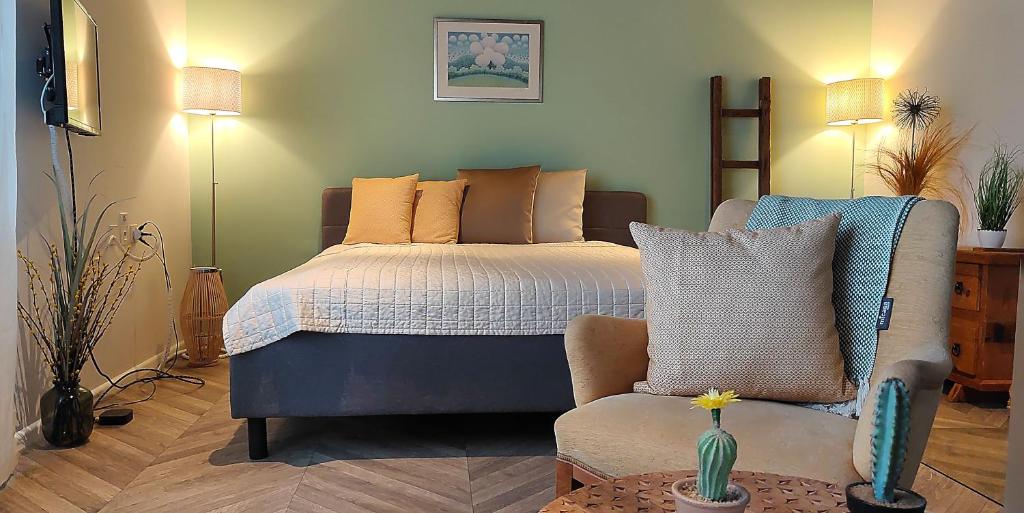 ein Schlafzimmer mit einem Bett, einem Sofa und einem Stuhl in der Unterkunft Chalet Tannegg in Reichenbach
