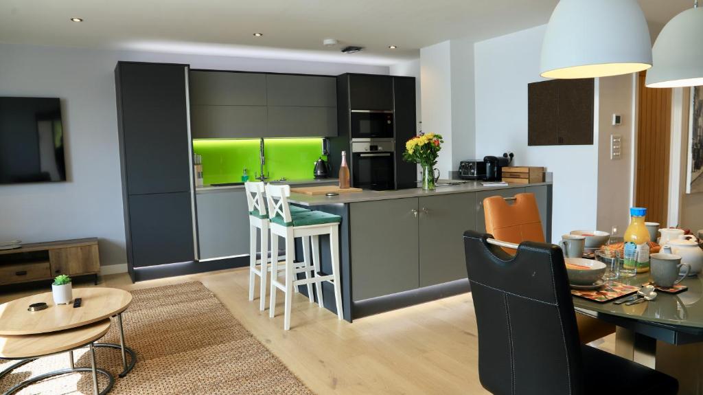 a kitchen and dining room with a green kitchen at Apartment Seven in Shrewsbury