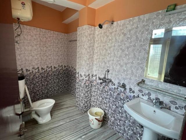 a bathroom with a toilet and a sink at Khandroling Hotel in Gangtok