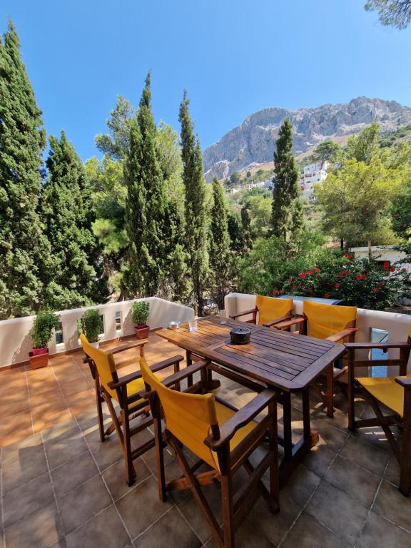 a wooden table and chairs on a patio at Cozy Kalydna House in Myrties